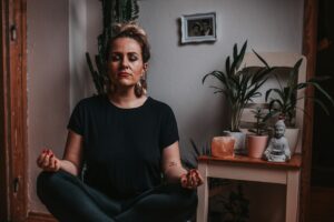 woman in black sitting down and meditating