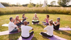 meditation teacher sitting in a circle with students on grass