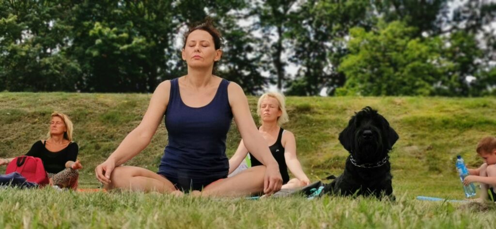woman meditating outside with her dog