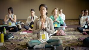 meditation class sitting on the floor. Hands together in prayer