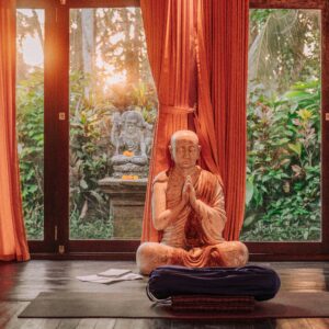 meditation cushion in front of a statue 