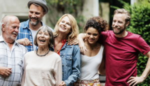 Group of people standing close together smiling and laughing