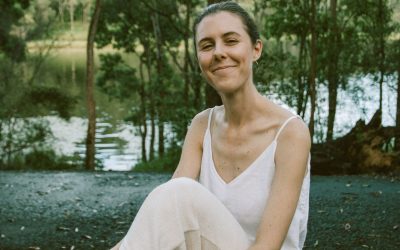 Woman in white sitting outside smiling